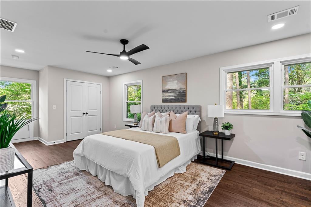 Staged primary bedroom with soft neutral bedding and blush pillows