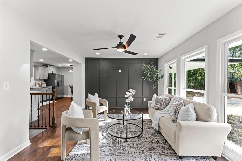 Staged living room with cream seating and a charcoal accent wall